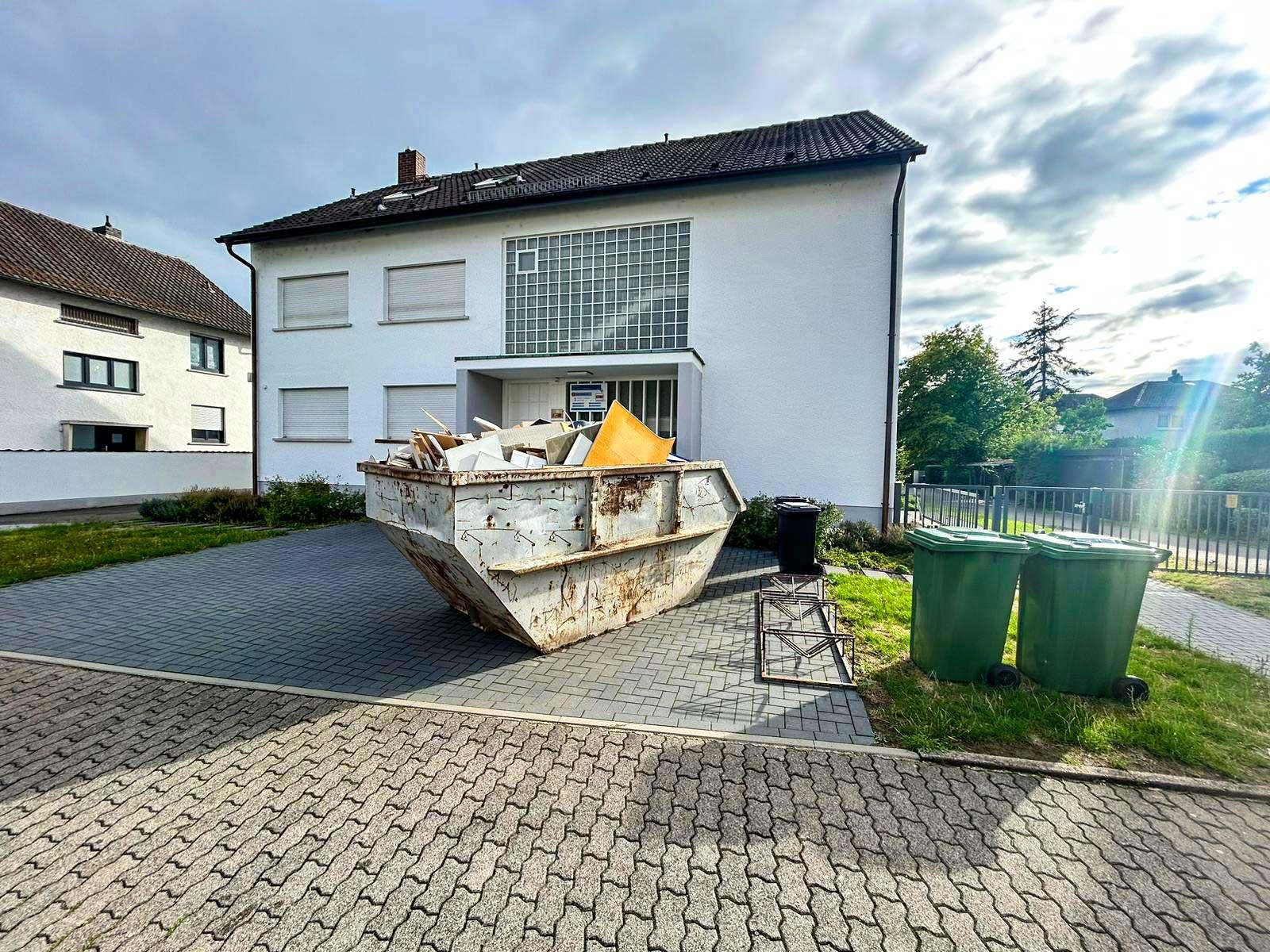 ARM Entsorgung beim Beladen eines Containers mit Sperrmüll während einer Entrümpelungsaktion in Frankfurt