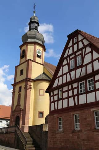 Elsenfeld: Kath. Pfarrkirche St. Ubaldis und Gertrudis (Wahrzeichen §6) mit Fachwerkhaus daneben, Ortskern Elsenfeld: Kath. Pfarrkirche St. Ubaldis und Gertrudis (Wahrzeichen §6) mit Fachwerkhaus daneben, Ortskern