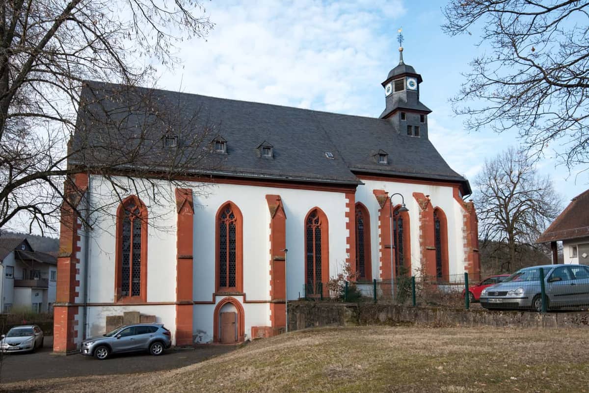 Hirzenhain: Ev. Hallenkirche / ehem. Augustinerkloster St. Maria (Hauptwahrzeichen), Suedostansicht mit Apsis und Dachreiter, blauer Himmel