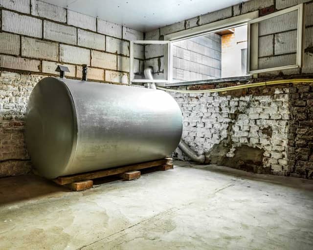 Alter Heizöltank und Heizkessel im Keller, bereit für die Demontage
