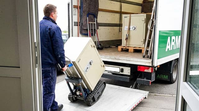 Tresor wird auf einem Raupentreppenlift über die Ladebordwand in den LKW gefahren Tresor wird auf einem Raupentreppenlift über die Ladebordwand in den LKW gefahren